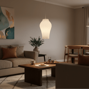 A modern white pendant light hangs above a wooden coffee table with snacks, enhancing a cozy living room ambiance.