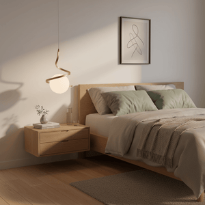 Gold infinity pendant light hanging above a wooden bedside table in a cozy bedroom setting.