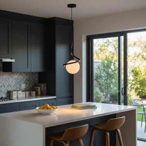 Black Infinity Pendant Light hanging above a kitchen island with a bowl of lemons and books.