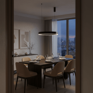 A black LED pendant light hangs above a wooden dining table set with beige chairs and tableware, in a softly lit room.