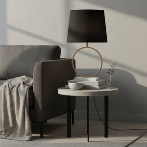 Stylish black and gold marble table lamp on a modern side table beside a sofa.