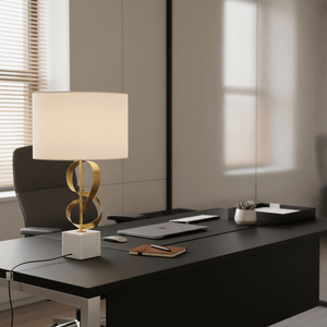 Gold and marble table lamp on a modern black desk with a laptop and notebook.