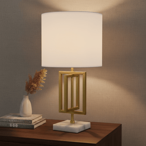 Chopin Gold & Marble Table Lamp on a wooden side table with decorative books and a vase.