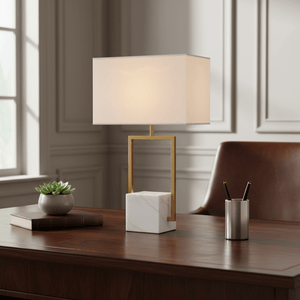 Verdi Gold & Marble Table Lamp on a wooden desk, featuring a marble base and fabric shade, with a succulent and books nearby.