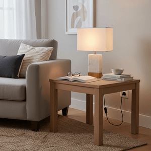 Bach Gold & Marble Table Lamp on a wooden side table beside a sofa, illuminating an open book.