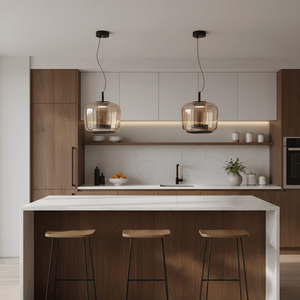 Two amber glass pendant lights hang above a modern kitchen island with wooden accents.