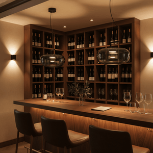 Modern green-tinted glass pendant lights above a wooden bar with wine bottles in the background.