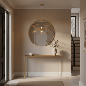 Satin gold twin pendant light hanging above a wooden console table in a stylish entryway.