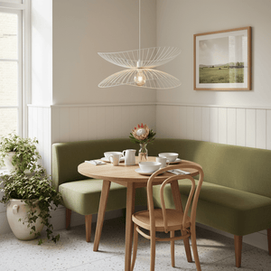 Stylish Sensu Twin White Pendant Light above a round wooden dining table with green seating and plants.