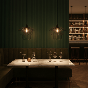 Stylish dining setup featuring two black pendant lights above a marble table with decorative elements.