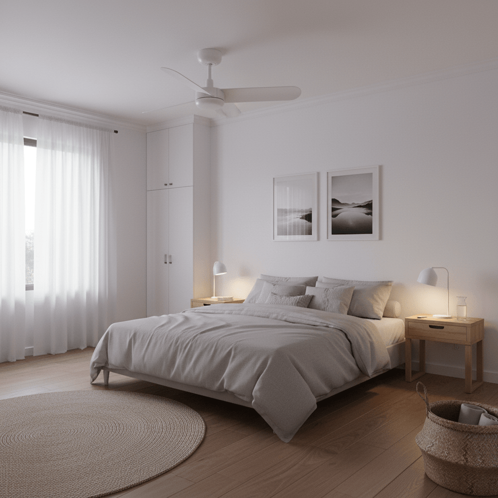 A modern bedroom featuring a white ceiling fan above a neatly made bed with soft gray bedding and wooden nightstands.