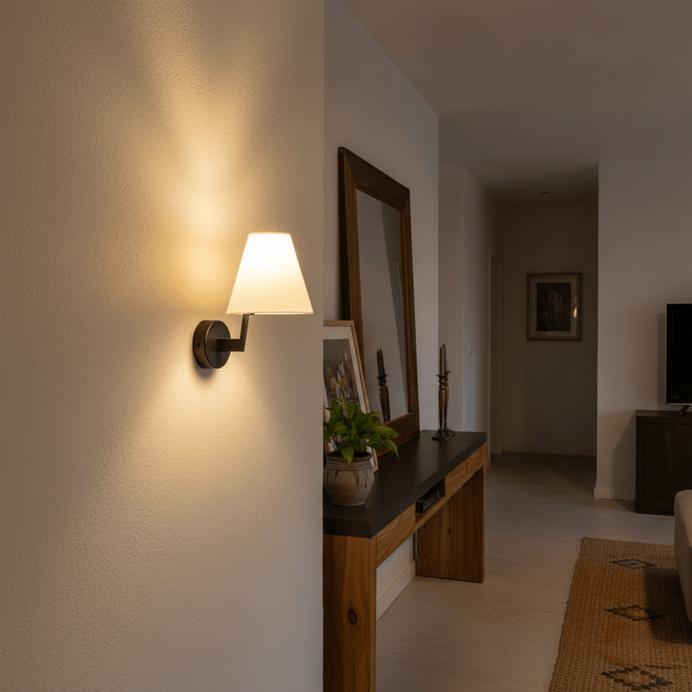 Contemporary indoor wall light casting a warm glow, mounted beside a mirror in a stylish living space.