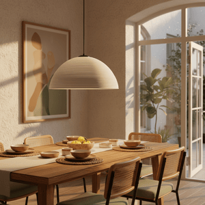 Small antique white rattan pendant light hanging above a wooden dining table set with bowls and a fruit centerpiece.