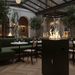 A stylish black fire cube heater with flames visible, set in a cozy indoor dining area with green seating.