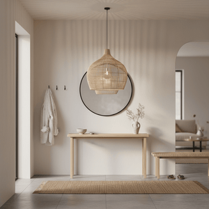 A bamboo rattan pendant light hangs above a wooden table in a modern, minimalist interior with a mirror and decorative