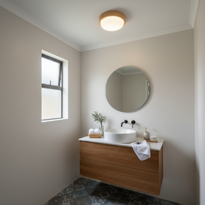 Bathroom with wooden vanity, round mirror, and window