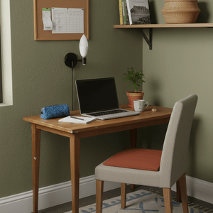A cozy workspace featuring a wooden desk with a laptop, a plant, and a wall-mounted light fixture with a frosted LED bulb.