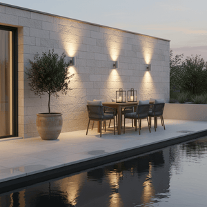 Outdoor scene featuring the Beam Up Down Wall Light illuminating a patio area with a dining table and chairs.