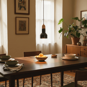 Stylish black marble and gold pendant light hanging above a dining table set with plates and a bowl of lemons.