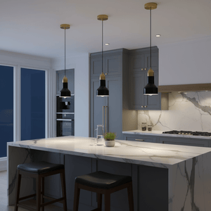 Three black marble and gold pendant lights hang above a modern kitchen island with a marble countertop.