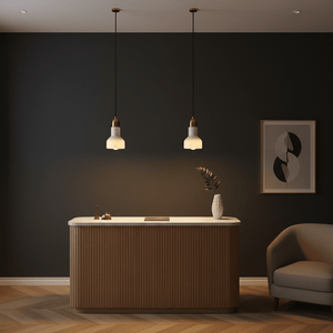 Two marble and gold pendant lights hang above a stylish wooden counter in a modern interior.
