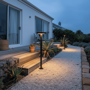 Modern solar bollards illuminating a garden pathway with warm light, surrounded by plants and steps.