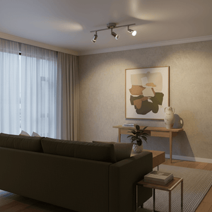 Three-head satin chrome ceiling track spotlight shines on a living room with sofa, console, artwork and plant.
