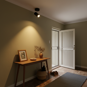 Adjustable matt black ceiling spotlight illuminating a hallway with a wooden console table and decor.