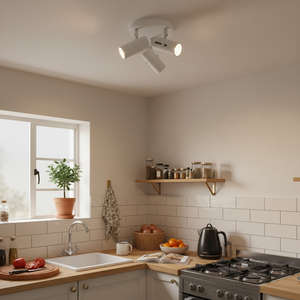 Three adjustable white spotlights mounted on the ceiling, illuminating a modern kitchen with a sink and wooden countertop.