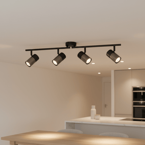 Black 4-light spotlight with adjustable arms mounted on a ceiling above a kitchen island.