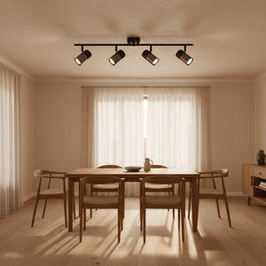 Black 4-light spotlight with moveable arms installed above a wooden dining table in a bright room.
