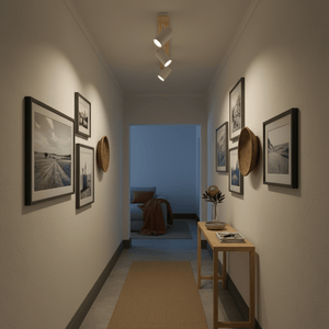 Hallway with white and wood quad spotlight illuminating framed photos and decor.