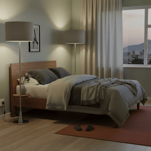Satin chrome standing floor lamp beside a bed, providing warm light in a cozy bedroom setting.