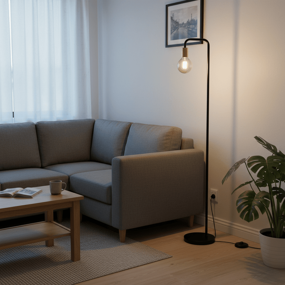 Modern black floor lamp beside a gray sofa, providing ambient light in a cozy living room setting.