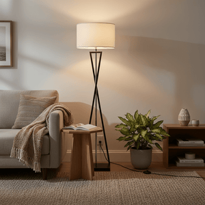 Collins Floor Lamp beside a cozy sofa, illuminating a reading nook with a book and plant nearby.
