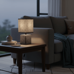 Modern table lamp with a textured shade on a wooden side table beside a cozy sofa, creating a warm ambiance.