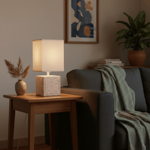 Modern table lamp with a ceramic base on a wooden side table, cozy living room setting.