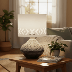 Bali Grey Table Lamp on a wooden side table, featuring a ceramic base and patterned shade, with a cozy living room backdrop.