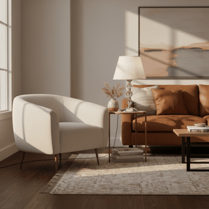 Myrna Satin Chrome Table Lamp on a side table next to a cozy armchair and sofa, enhancing the warm ambiance.