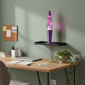 Purple lava lamp on a wall-mounted shelf above a desk with a laptop, notebook, and plant, creating a calming workspace