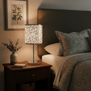 Polished chrome table lamp with silver patterned shade on a bedside table, surrounded by decor.