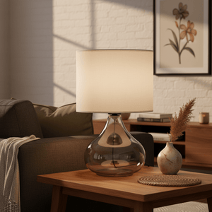 Wilson Smoke & Beige Table Lamp on a wooden side table, with a cozy couch and decorative vase in the background.