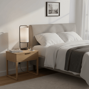 Watson Black & White Cylinder Table Lamp on a bedside table beside a bed with soft linens.