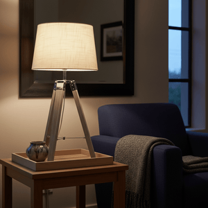 Arabella Wood & Chrome Table Lamp on a side table, illuminating a cozy living room setting with a blue armchair.