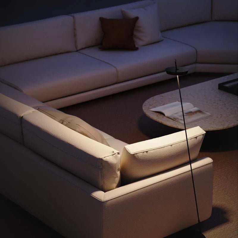 Rechargeable LED floor lamp beside a modern sofa, illuminating a cozy reading nook with warm light.