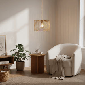 Gold wire pendant light hanging above a cozy armchair and side table in a softly lit room.