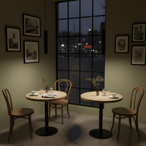 A black Flute GU10 pendant light hangs above a cozy café table setting with wooden tables and chairs.