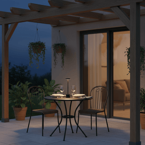 A stylish black rechargeable table lamp on a dining table outdoors, surrounded by plants and a cozy setting.