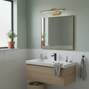 Antique bronze picture light mounted above a bathroom mirror, illuminating the space with a warm glow.