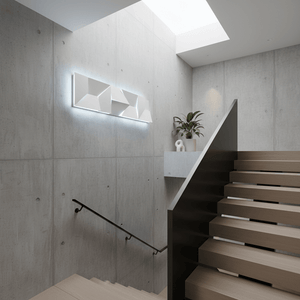 Mosaic rectangle LED wall light mounted on a concrete wall, illuminating a modern staircase.